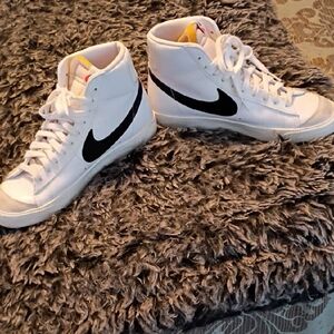 Nike White High-Top Sneakers with Black Swoosh and Yellow Tongue Accent.